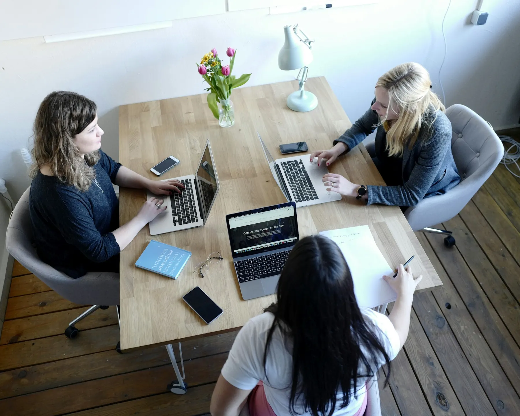 Petite équipe de trois personnes au travail autour d’une table en bois
